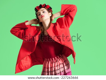 Fashion model girl in red dress pose on green background