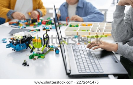 Robotics programming class. Children construct and code Robot. STEM education using constructor blocks and laptop, remote control joystick. Technology educational development for school kids Royalty-Free Stock Photo #2272641475