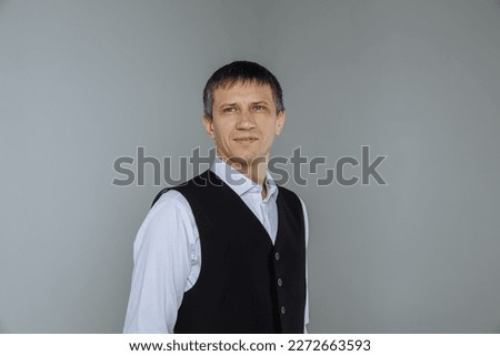 Male portrait in a classic shirt and vest on a gray background