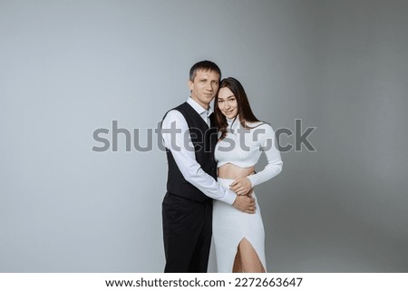 A man and a woman on a gray background of a photo studio