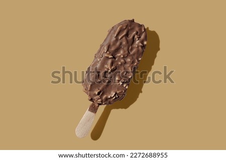 Chocolate ice cream on a stick brown pastel background