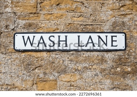 Wash Lane street sign isolated against a brick wall background