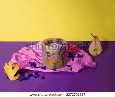 Creative set design of flower's candle. A pear and a ginger on the bright contemporary background.