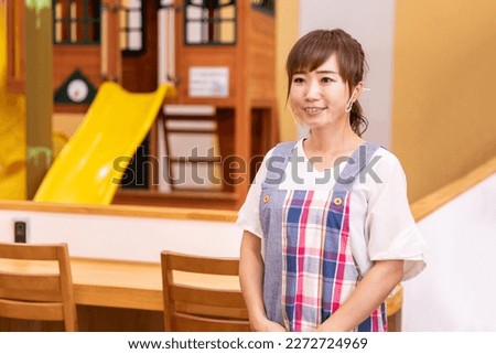 A woman in an apron wearing a transparent mask Royalty-Free Stock Photo #2272724969