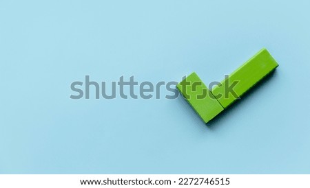 Checklist concept. Accomplishment of objectives or goals. Green Wooden check mark on blue background. Copy space. Royalty-Free Stock Photo #2272746515