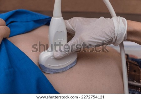 An abdominal ultrasound procedure on an overweight male patient. Checking for bowel, kidney, liver or intestinal disease, and other organs in the abdominal cavity. Royalty-Free Stock Photo #2272754121