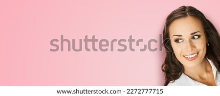 Young happy smiling woman in white confident cloth looking aside. Business advertise concept. Brunette businesswoman, isolated on rose pink background.