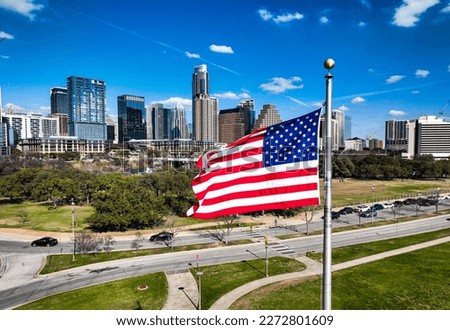 American Flag on perfect flag pole flying patriotic flag in front of the Austin Texas USA Skyline Cityscape over a capital city Royalty-Free Stock Photo #2272801609