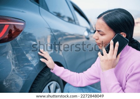 Woman checking car damage after car crash Royalty-Free Stock Photo #2272848049