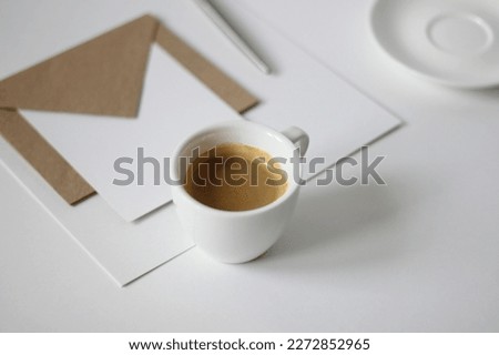 Minimalist White Office Desk with Cup of Espresso, Papers, Envelopes, Cards. Coffee Break Refreshment.