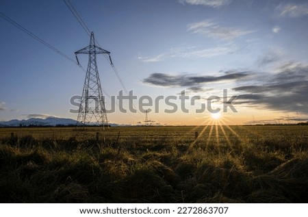 High voltage power pylon towers and powerlines at sunrise, Canterbury, South Island Royalty-Free Stock Photo #2272863707