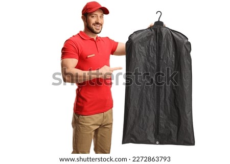 Worker holding clothes on a hanger with a cover and pointing isolated on a white background

