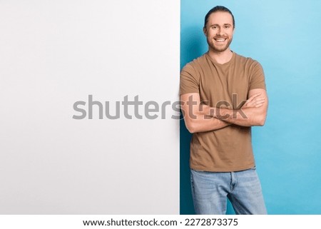 Photo of pretty sweet guy dressed beige t-shirt arms crossed white placard emtpy space isolated blue color background