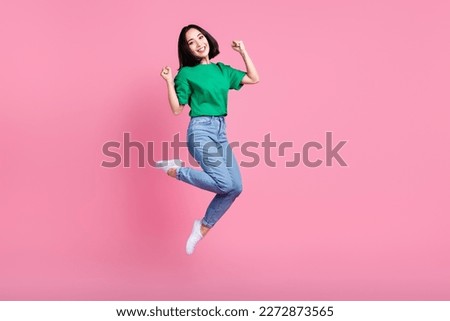 Full size photo of lovely woman wear oversize t-shirt jeans clenching fists looking forward to shopping isolated on pink color background