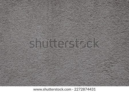 Surface of dusty wall with coarse light gray roughcast finish
