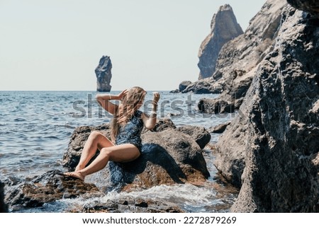Woman summer travel sea. Happy tourist enjoy taking picture outdoors for memories. Woman traveler posing on the beach at sea surrounded by volcanic mountains, sharing travel adventure journey
