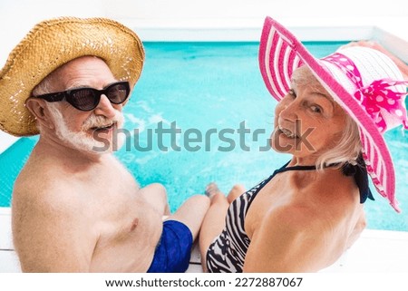 Happy senior couple having party in the swimming pool - Elderly friends releaxing at a pool party during summer vacation Royalty-Free Stock Photo #2272887067