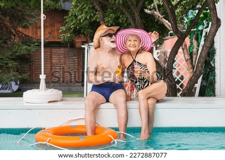 Happy senior couple having party in the swimming pool - Elderly friends releaxing at a pool party during summer vacation Royalty-Free Stock Photo #2272887077