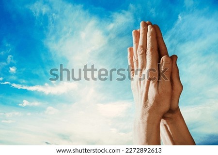 Hands praying on blurred of blue sky backgrounds. Faith in Jesus Christ. Christianity. Church worship, salvation concept. Faith symbol. Gate to heaven. Eternal life of soul. Christianity gospel