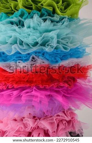draped background of colorful powdery fabric in the form of tulle, texture textile surface. Texture background from the airy fabric of the dress. Copy space for text about design and fashion. 