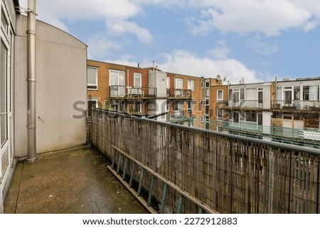 an outside area with some buildings in the background and blue sky above it, as seen from a balcony on a sunny day Royalty-Free Stock Photo #2272912883