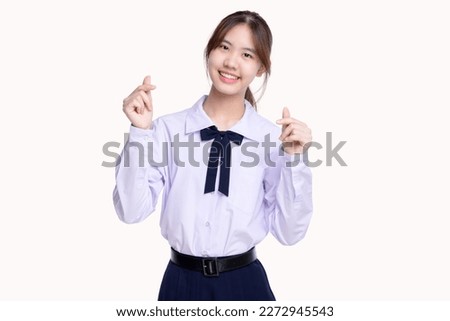 Happy pretty Asian student girl in school uniform showing mini heart sign isolated on white background.