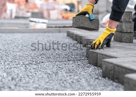 laying interlocking pavers during the construction of sidewalks and roads. copy space Royalty-Free Stock Photo #2272955959