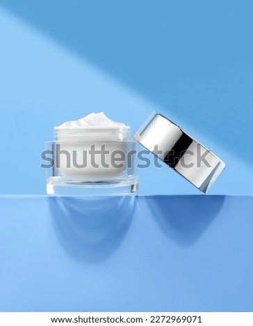 Blue background plain cream white cream skin care products cosmetics Royalty-Free Stock Photo #2272969071