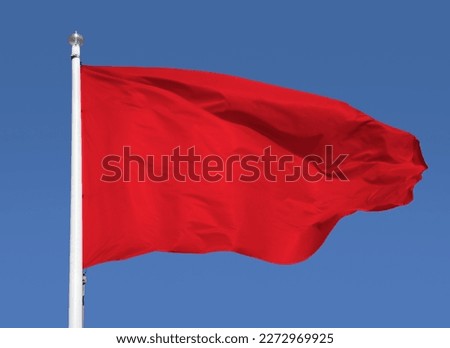 Close up of red flag with sky background and copy space