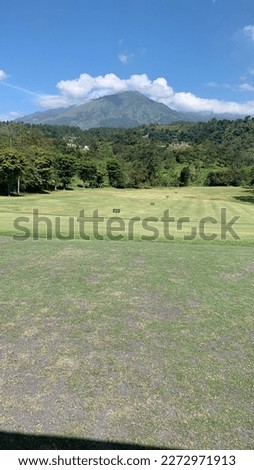 sunny weather on golf course with mountain background
