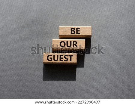 Be our guest symbol. Concept word Be our guest on wooden blocks. Beautiful grey background. Business and Be our guest concept. Copy space