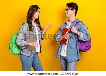 Photo of pretty cute groupmates wear jeans talking discussing homework isolated yellow color background