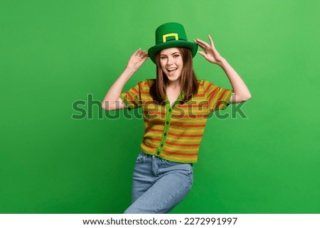 Portrait of cheerful cute young person toothy smile hands touch hat isolated on green color background
