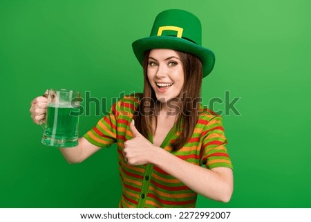 Photo of positive lady in leprechaun suit advertise thumb up reaction to patrick ale lager glass isolated green color background