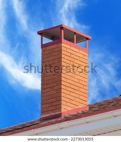 brick smokestack on background of blue sky