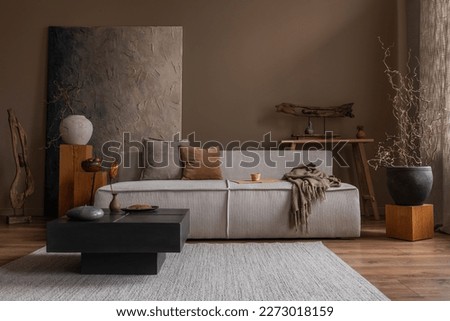 Interior design of wabi sabi living room interior with mock up poster frame, modular sofa, gray rug, vase with branch, bench, wooden sculpture and personal accessories. Home decor. Template. 