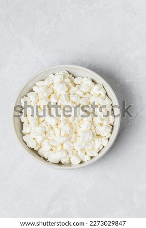 Natural cottage cheese  in white bowl isolated on light background, top view  Royalty-Free Stock Photo #2273029847