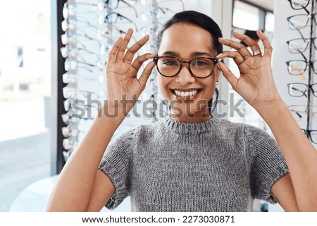 The best eyewear brands in the optometry business. Shot of a young woman buying a new pair of glasses at an optometrist store. Royalty-Free Stock Photo #2273030871