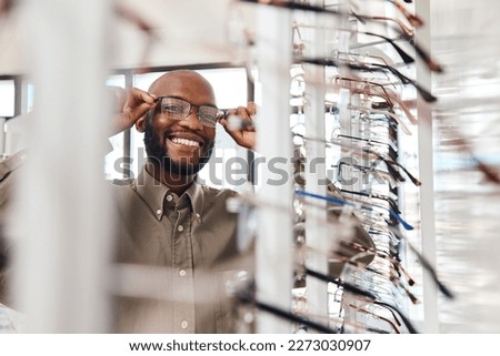 The perfect pair for me. Shot of a young man buying a new pair of glasses at an optometrist store. Royalty-Free Stock Photo #2273030907