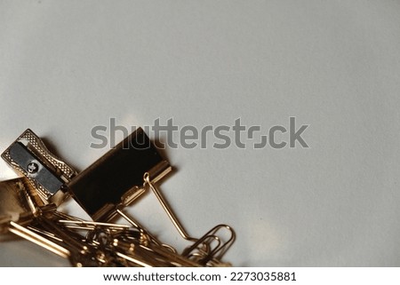 Assorted stationery, sharpeners, paper clips and bulldog clips, all on gold against some beautiful cream parchment paper. Use as a desktop background or a PowerPoint or slideshow backdrop