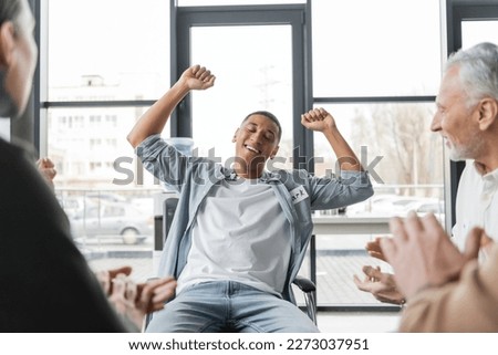 Excited african american man with alcohol addiction showing yes gesture during group therapy session Royalty-Free Stock Photo #2273037951