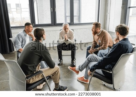 Multiethnic people with alcohol addiction sitting in circle in rehab center Royalty-Free Stock Photo #2273038001