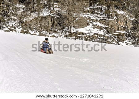 Beautiful young winter sport girl sledding in the snowy mountains of the Hautes Pyrenees