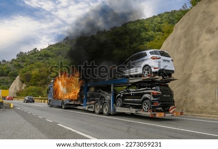The truck transporting cars caught fire on the way. Fire caused by an electrical short circuit in one of the transported cars. No logo, brand.