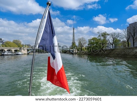 City trip Paris - French national flag tricolor on a pleasure boat on the Seine with the Eiffel Tower in the background