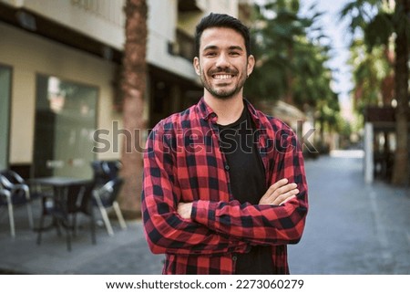 Young hispanic man smiling confident standing with arms crossed gesture at street Royalty-Free Stock Photo #2273060279