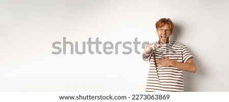 Young man with ginger hair and beard pointing finger at camera and laughing, making fun of someone hilarious, standing over white background. Royalty-Free Stock Photo #2273063869