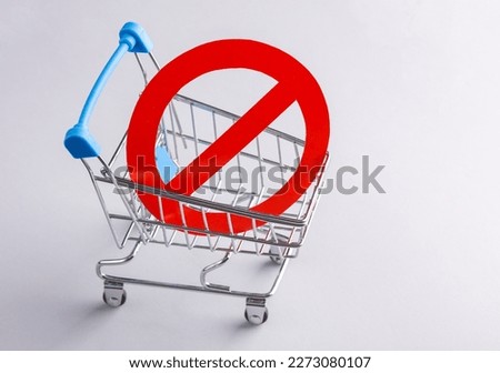 Shopping trolley with prohibition sign on gray background