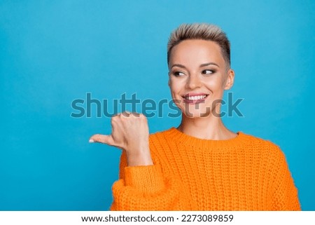 Photo portrait of attractive young woman point look beaming toothy smile wear trendy orange garment isolated on blue color background