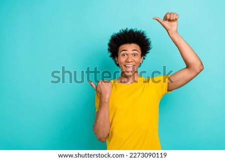 Photo of impressed guy afro hairstyle dressed yellow t-shirt directing empty space open mouth isolated on turquoise color background